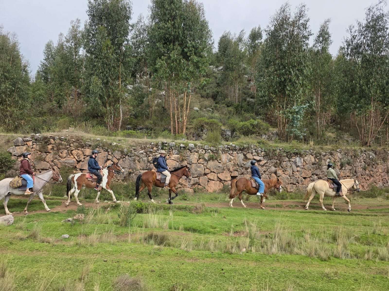 Horseback riders along ancient Inca stone wall near Cusco