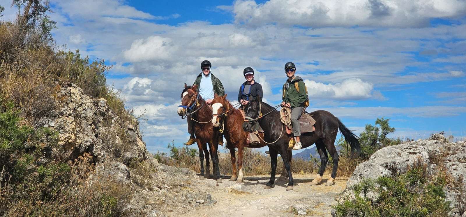 Three horseback riders on rocky trail near Cusco