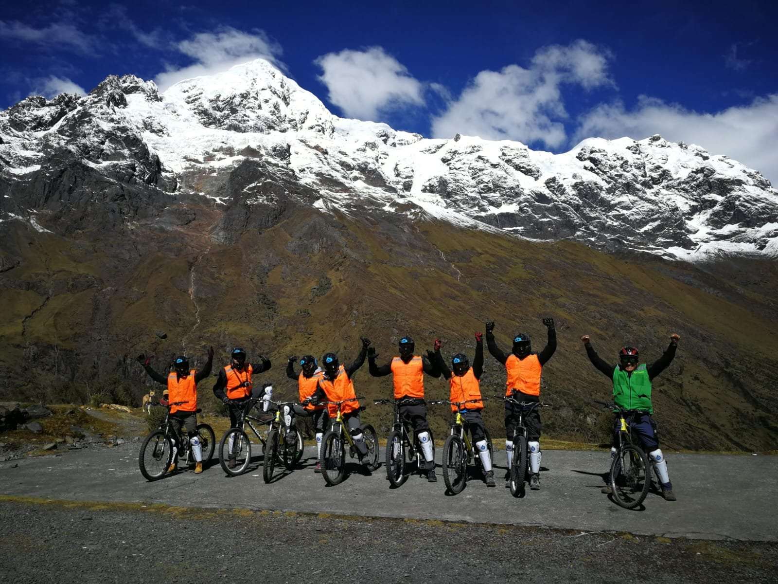 Inca Jungle Trail mountain bikers at Abra Malaga pass with snow-capped Andes mountains