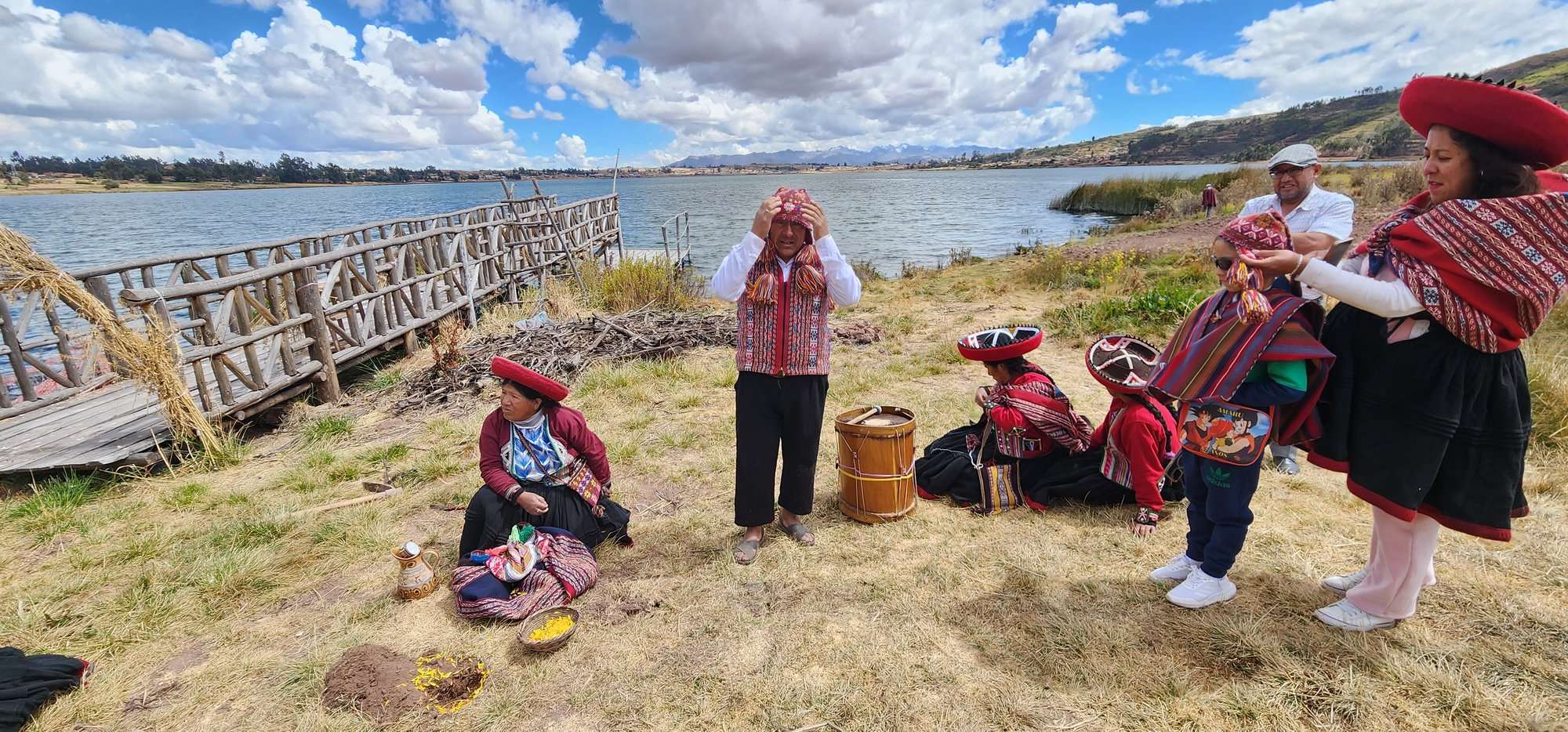 Hosts in traditional Andean dress beside the lagoon near Chinchero during a pachamanca experience